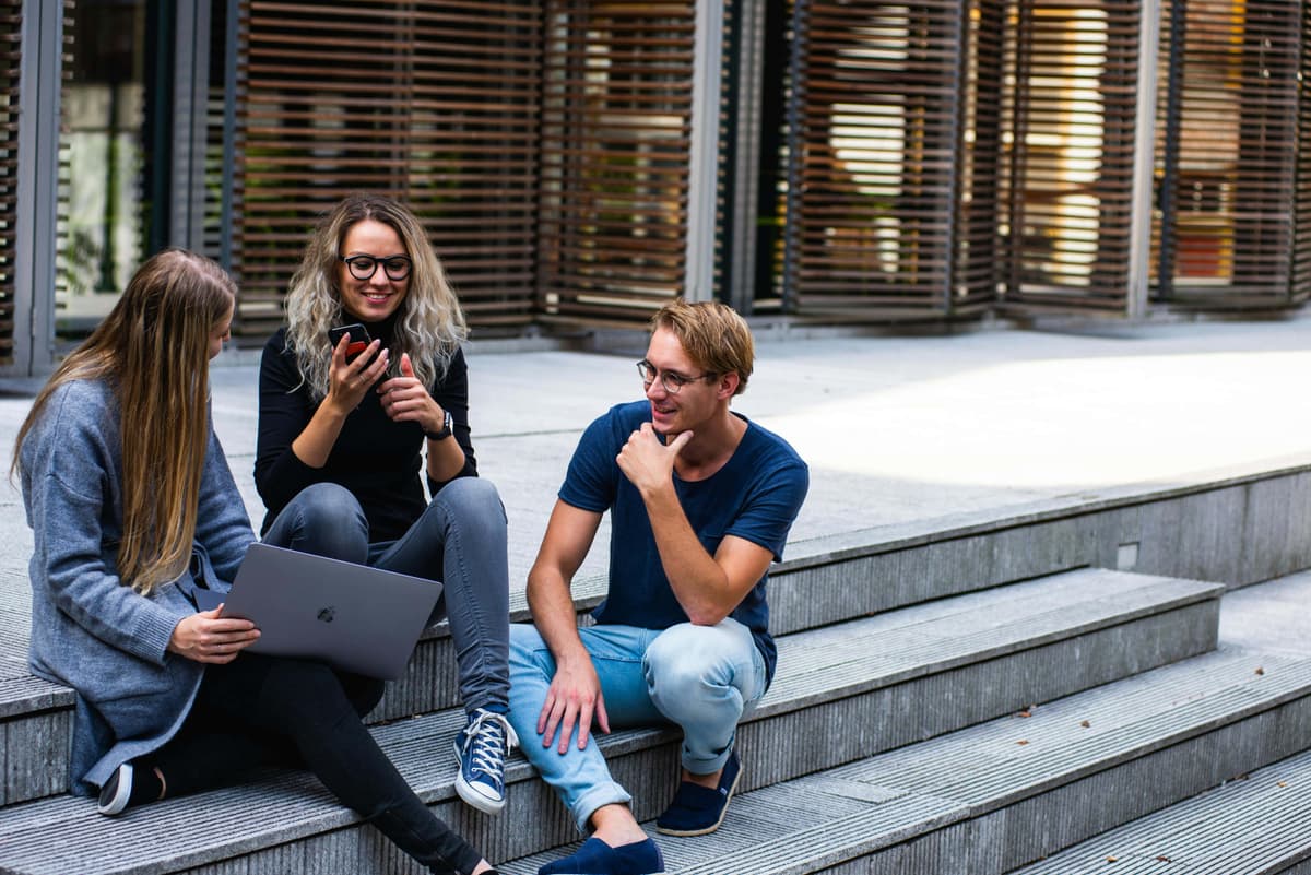 “Three Persons Sitting on the Stairs Talking with Each Other”