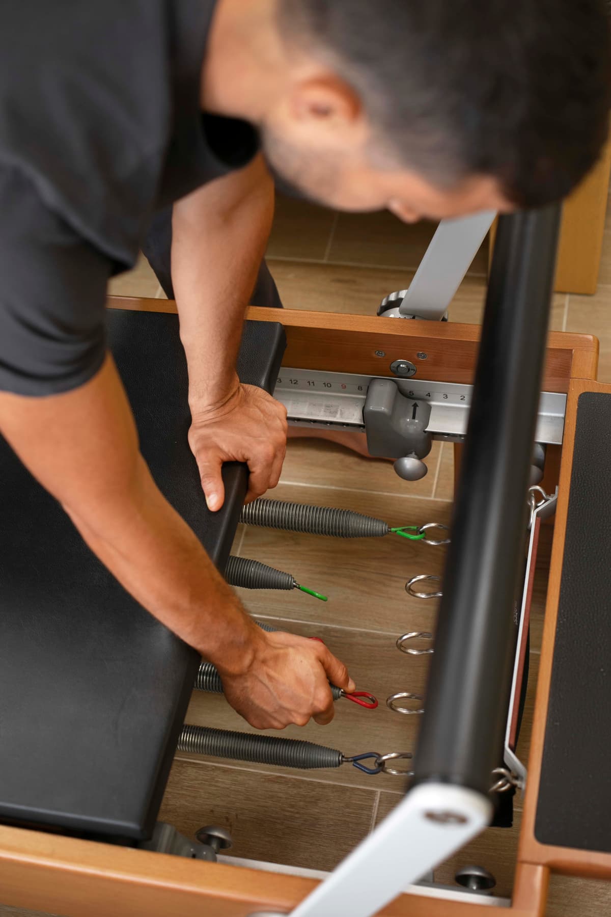 high-angle-man-checking-pilates-equipment Pilates for beginners
