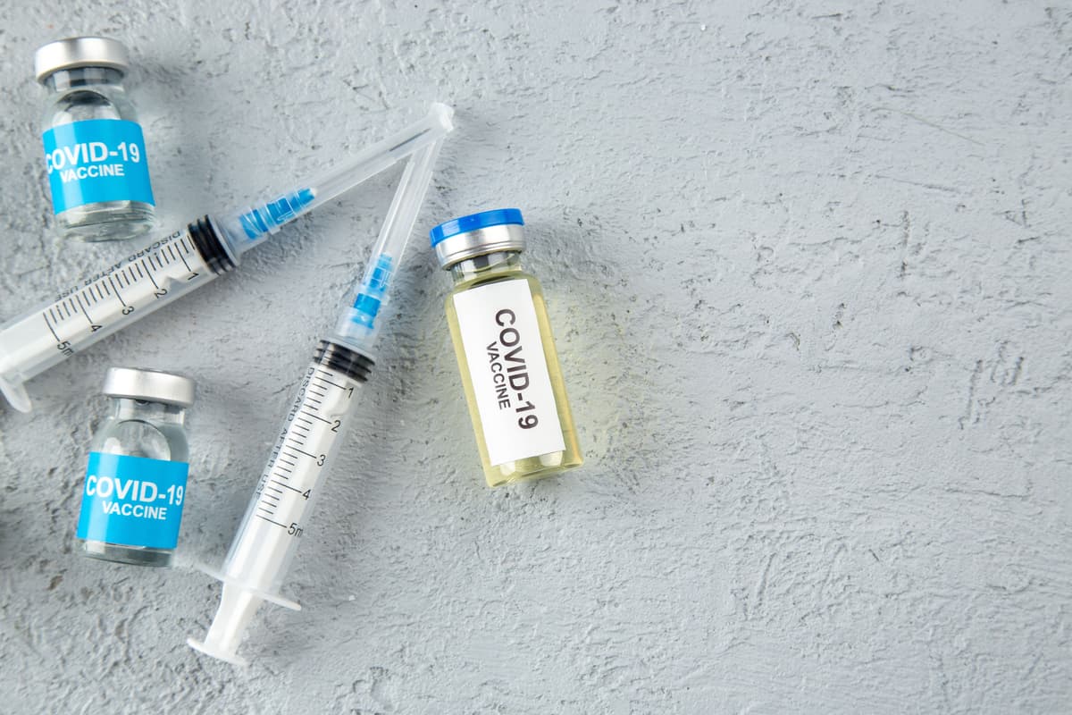 front-view-various-covid-vaccines-syringes-right-side-gray-sand-background